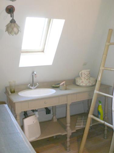 une salle de bain avec un lavabo et une fenêtre dans l'établissement Maison de charme avec piscine privée à Sainte-Alvère, à Saint-Alvère
