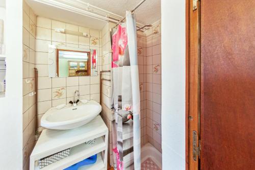 ein Bad mit einem Waschbecken und einem Spiegel in der Unterkunft Studio avec vue sur le lac jardin amenage et wifi a Gerardmer a 1 km des pistes in Gérardmer
