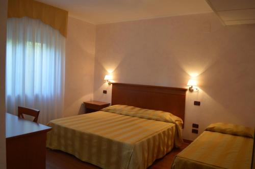una camera d'albergo con due letti e una finestra di Hotel Parco Serrone a Corato