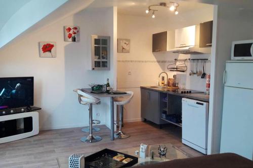- une petite cuisine avec une table et un comptoir dans l'établissement Studio agréable et central à Compiègne - 31 m² avec parking, à Compiègne