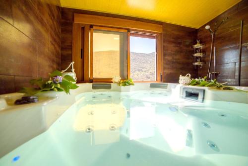 a large bath tub in a bathroom with a window at Cozy Chalet in Laroya + Pool in Laroya