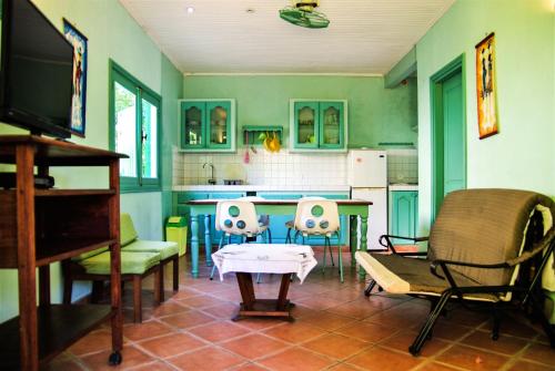 cocina con sillas, mesa y TV en One bedroom house at Foulpointe Madagascar 10 m away from the beach with sea view enclosed garden and wifi en Foulpointe