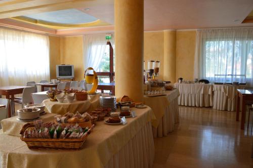una grande sala con tavoli e sedie e un buffet di Hotel Parco Serrone a Corato