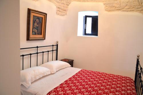 ein Schlafzimmer mit einem Bett mit einer roten Decke in der Unterkunft Trulli Casa Alberobello in Alberobello
