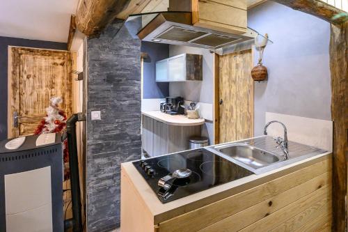 a small kitchen with a sink and a stove at Appartement spacieux à Orcières – Vue sur la montagne. in Orcières