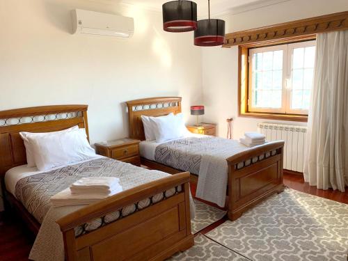 a bedroom with two beds and a window at 9 bedrooms villa with private pool jacuzzi and enclosed garden at Ponte de Lima Viana do Castelo in Ponte de Lima