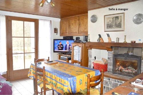 un salon avec une table et une cheminée dans l'établissement Maison de charme à Ferrières-Saint-Mary avec vue montagne, à Ferrières-Saint-Mary