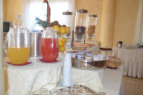 a table with two glasses of juice and fruit at Hotel Parco Serrone in Corato