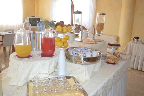 a table with some drinks and bowls of fruit at Hotel Parco Serrone in Corato