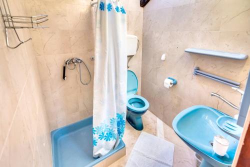uma casa de banho com um WC azul e um lavatório. em One bedroom appartement at Zlarin 200 m away from the beach with sea view enclosed garden and wifi em Zlarin