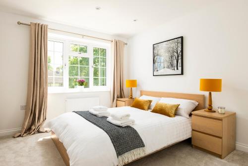 a bedroom with a large white bed with a window at 2 bed house close to Town Centre in Bracknell