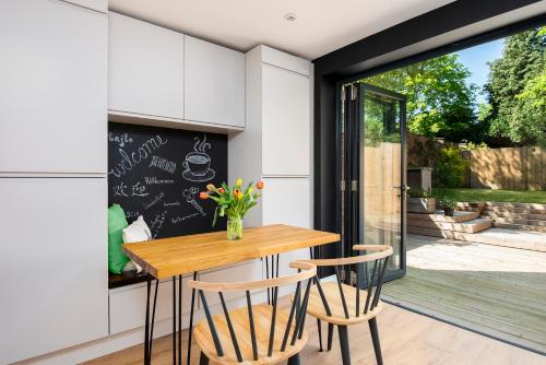 a kitchen with a table and chairs and a window at 2 bed house close to Town Centre in Bracknell