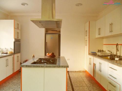 a kitchen with white cabinets and a stove top oven at Hostal Magnolio in Viña del Mar