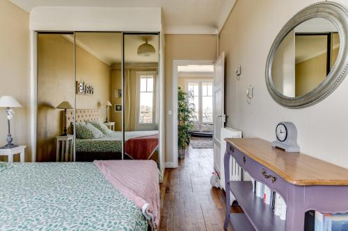 une chambre avec un lit et un miroir dans l'établissement Appartement moderne à Saint-Denis - 65 m² avec balcon, à Saint-Denis