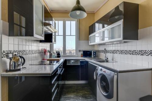 Il comprend une cuisine équipée d'un évier et d'un lave-linge/sèche-linge. dans l'établissement Appartement moderne à Saint-Denis - 65 m² avec balcon, à Saint-Denis