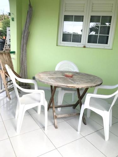 a wooden table and two white chairs and a table and chairs at Appartement avec vue sur la mer à Le Marin, Climatisé, 80 m² in Le Marin