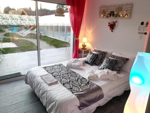 une chambre avec un lit et une grande fenêtre dans l'établissement Appartement moderne avec piscine à Plan-d'Aups 55 m² - Spa inclus​, à Plan dʼAups
