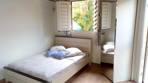 a small bedroom with a bed and a window at Charmant Bungalow avec Piscine Partagée à Le Gosier in Le Gosier
