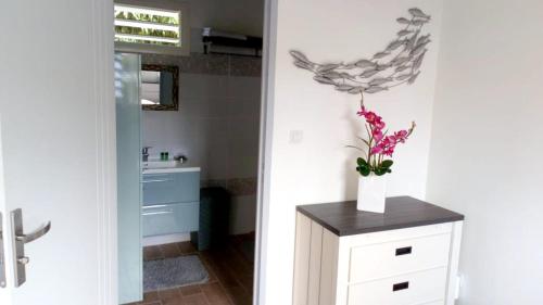 a bathroom with a vase of flowers on a counter at Charmant Bungalow avec Piscine Partagée à Le Gosier in Le Gosier