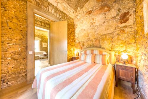 ein Schlafzimmer mit einem Bett in einer Steinmauer in der Unterkunft 4 bedrooms house with sea view shared pool and enclosed garden at Quelfes in Quelfes