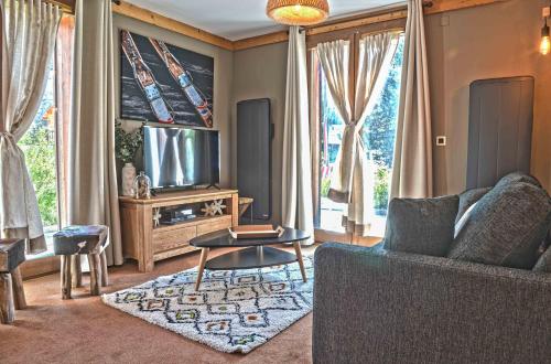 a living room with a couch and a tv at Appartement de 2 chambres a Les Deux Alpes a 50 m des pistes avec terrasse amenagee et wifi in Mont-de-Lans