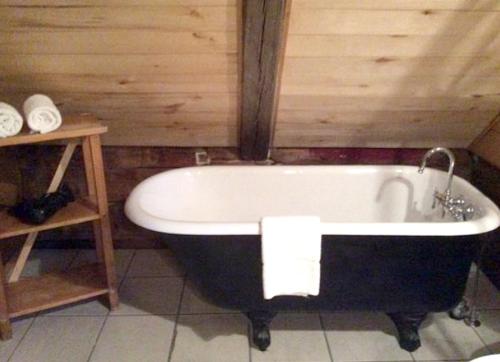 y baño con bañera y pared de madera. en Maison de 2 chambres a Notre Dame de Bellecombe a 100 m des pistes avec jardin amenage et wifi en Notre-Dame-de-Bellecombe