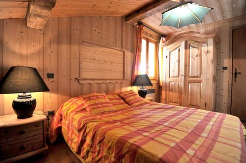 シャンパニー・アン・ヴァノワーズにあるAppartement de 4 chambres a Champagny en Vanoise a 400 m des pistes avec jardin clos et wifiのベッドルーム1室(ベッド1台、ランプ2つ付)