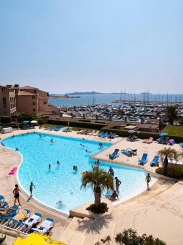 - une grande piscine avec des chaises et des personnes dans l'établissement Appartement charmant près de la plage et une piscine (32 m²), à Six-Fours-les-Plages