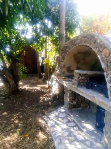a stone bench sitting next to a stone oven at Bungalow cosy à Saint-Leu, vue sur la mer. in Saint-Leu