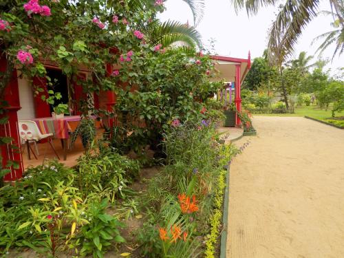 a garden with flowers on the side of a house at Comfortable Studio with Sea View in Foulpointe - 30 m² in Foulpointe