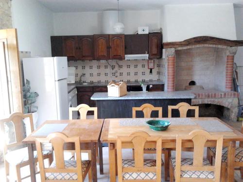 a kitchen with a table and chairs and a kitchen with a fireplace at Charming house in Alcobaça with mountain view in Alcobaça