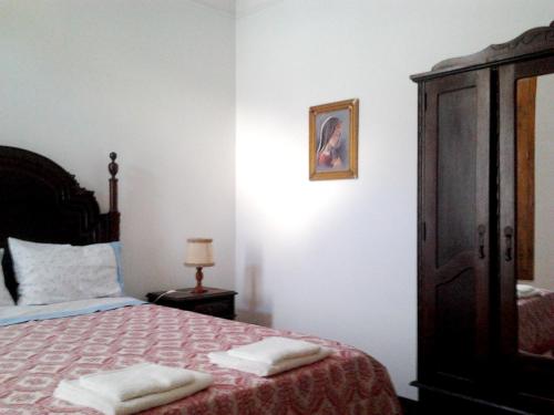 a bedroom with a bed with two towels on it at Charming house in Alcobaça with mountain view in Alcobaça