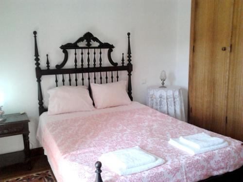 a bedroom with a bed with two towels on it at Charming house in Alcobaça with mountain view in Alcobaça