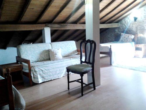 a chair in a living room with a couch at Charming house in Alcobaça with mountain view in Alcobaça