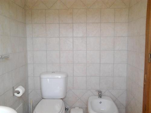 a white bathroom with a toilet and a bidet at Charming house in Alcobaça with mountain view in Alcobaça