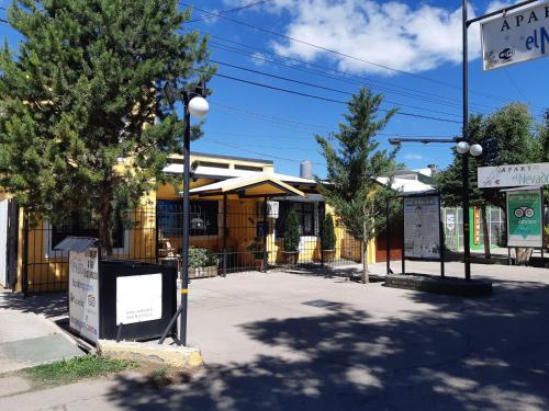 マラルグエにあるApart El Nevado Malargüeの建物と木々が前に並ぶ通り角