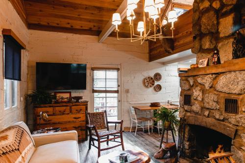 sala de estar con chimenea de piedra y TV en The Fireside Inn, en Idyllwild