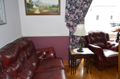a living room with a couch and a lamp on a table at Balcony House in Galway