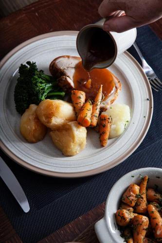 a plate of food with shrimp and broccoli on a table at Ellenborough Park in Cheltenham