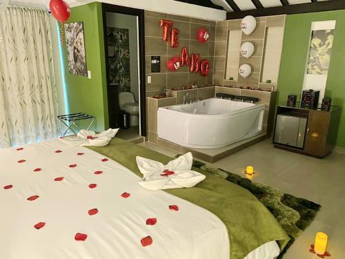 a large bathroom with a tub and a bed with roses on it at Hotel Jade Spa in Santa Rosa de Cabal