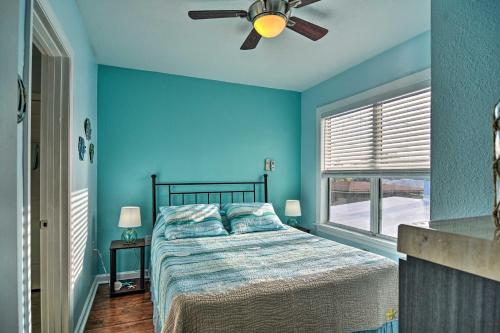 a bedroom with blue walls and a bed with a ceiling fan at Condo with Community Pool - Walk to Madeira Beach! in St Pete Beach