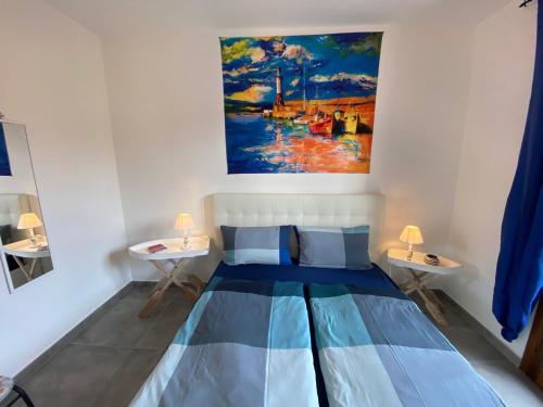 uma cama num quarto com uma pintura na parede em Il Faro La Ciaccia em Codaruina