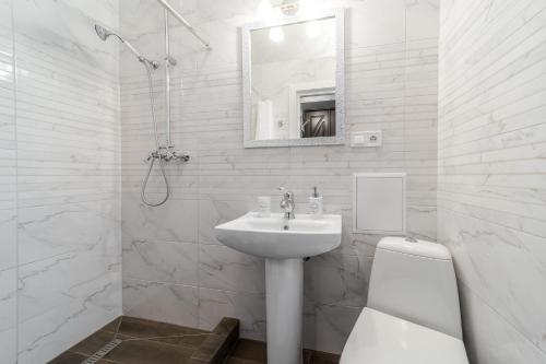 La salle de bains blanche est pourvue d'un lavabo et de toilettes. dans l'établissement Райська Насолода, à Lviv