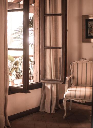 a chair sitting in front of a window at Casa Del Val - Villa María Hotel in San Bernardino