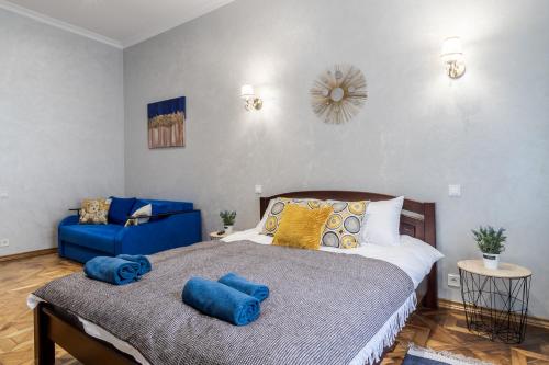 um quarto com uma cama e um sofá azul em Райська Насолода em Lviv