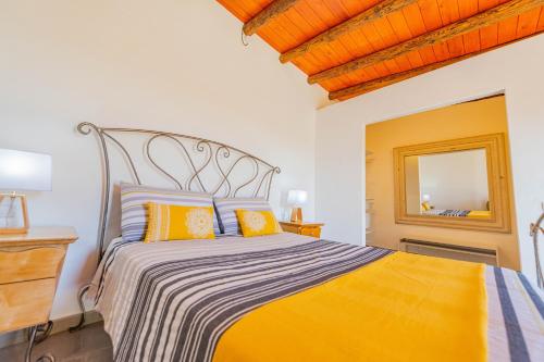 a bedroom with a bed with orange and yellow pillows at Casa Rural La Jicara in Tiscamanita