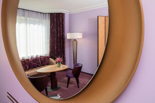a mirror in a room with a table and chairs at Hotel Maison FL in Paris