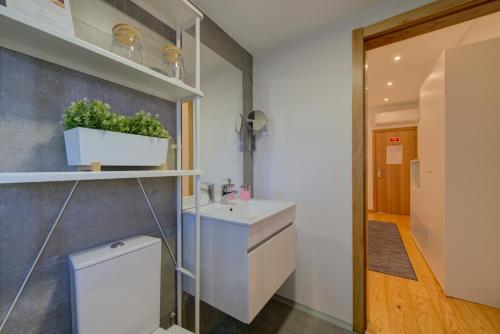 a bathroom with a sink and a toilet at Bellu Suites in Guimarães