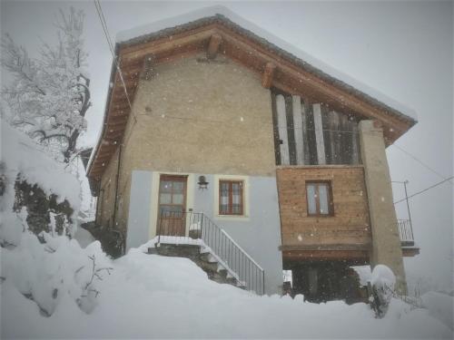 een huis bedekt met sneeuw in de sneeuw bij Locanda Al Torch - Ristorante e Camere in Stroppo