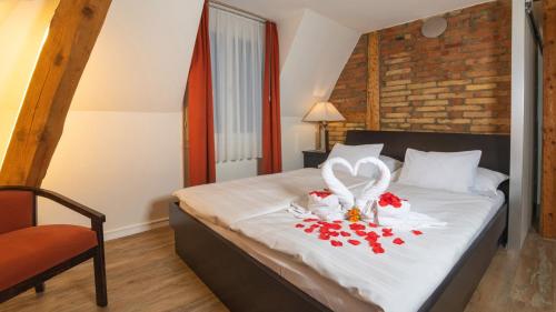 1 dormitorio con 1 cama con 2 cisnes y rosas en Swiss Inn & Apartments, en Interlaken